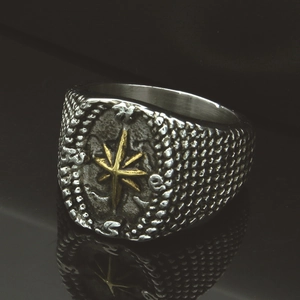 Detailed macro view of vintage stainless steel compass ring with golden star design