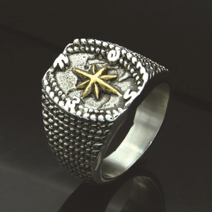 Macro shot of vintage steel compass ring with gold star and mirror reflection details
