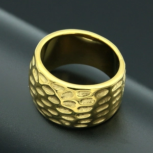 Detailed close-up of wide gold men's stainless steel ring with hammered texture
