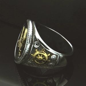 Detailed macro view of retro skull ring featuring gold rudder and nautical anchor relief