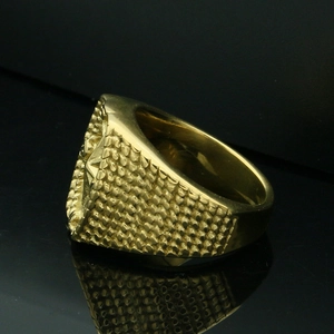 Detail shot of vintage gold compass ring with heavy brick texture on the side profile