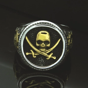 Retro steel pirate skull ring with golden skull and cross swords on a silver band