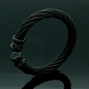 Vista detallada del brazalete rígido de cable trenzado en acero inoxidable negro