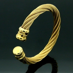 Vista macro de brazalete de cable de acero inoxidable dorado con puntas cilíndricas pulidas