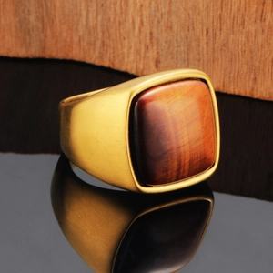 Detailed close-up of a vintage men's gold signet ring with a red tiger eye stone inlay