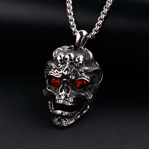 Gros plan d'un pendentif tête de mort gothique avec yeux en cristal rouge et détails argent