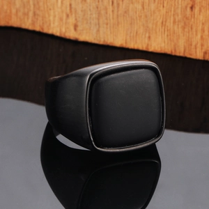 Macro shot of men's matte black titanium ring with a square signet design and brushed finish