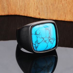 Macro shot of men's black textured ring featuring square blue turquoise stone inlay