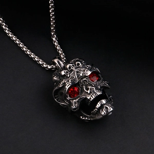 Gros plan du pendentif crâne punk avec yeux en strass rouges et texture en acier noirci