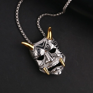 Macro detail of Hannya mask pendant with gold horns and teeth on punk steel chain