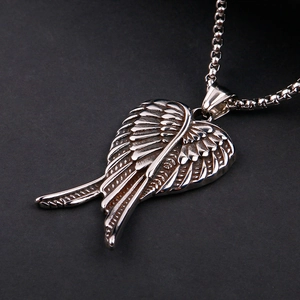 Macro shot of silver stainless steel angel wing pendant with detailed feather texture