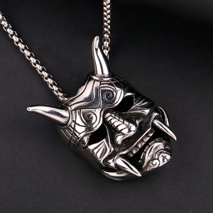 Detailed macro view of the silver stainless steel Hannya mask skull pendant on a ball chain