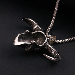 Detailed macro view of vintage stainless steel bull skull pendant on bead chain