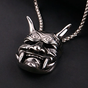 Macro shot of polished silver Hannya skull pendant with intricate punk metal textures