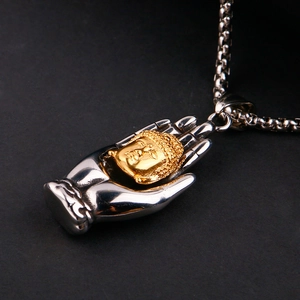 Macro detail of the stainless steel Buddha palm pendant with gold head on silver chain
