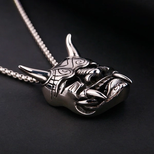 Macro shot of a silver steel Hannya mask pendant with square box chain in punk style