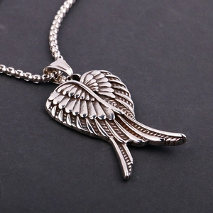 Detailed macro shot of a stainless steel wing pendant with fine feather textures and ball chain
