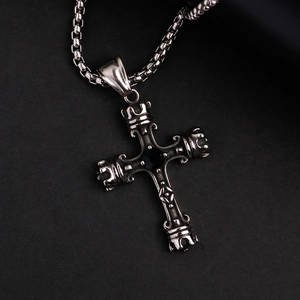 Détail macro du collier croix gothique avec pierre noire et éléments de couronne