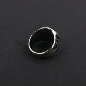 Macro detail of silver stainless steel signet ring with vintage embossed patterns