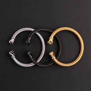 Vue détaillée de trois bracelets torsadés en acier avec terminaux en forme de poing, argent, or, noir