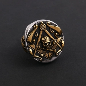Detalle macro del anillo masónico con calavera dorada y emblema de compás vintage