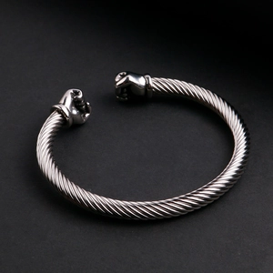 Détail de ce bracelet torsadé en acier inoxydable avec deux finitions en forme de poings