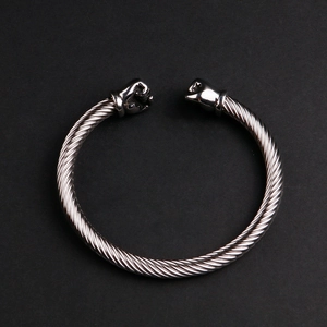 Vue détaillée du bracelet en fil torsadé argenté avec des motifs de poing réalistes