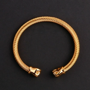 Gros plan sur le bracelet câble torsadé doré avec des extrémités en forme de poing