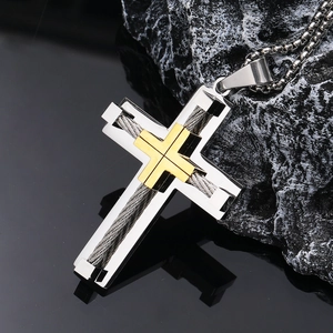 Macro view of stainless steel cross pendant with gold-tone wire inlay and bead chain