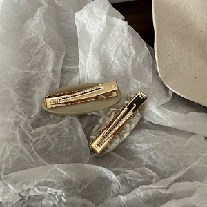 Minimalist oval acetate hair clips in khaki and marble pattern with golden metal duckbill grips