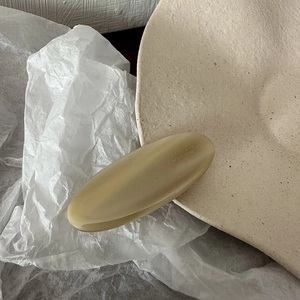 Detail view of oval acetate hair clip in beige with France Handmade engraving