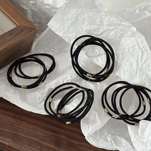 High-elastic slim hair ties with gold metal connectors on minimalist white background