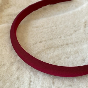 Vue détaillée de la texture du tissu sergé rouge foncé sur un serre-tête vintage