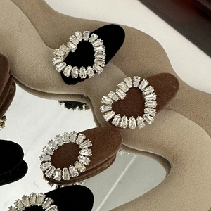 Macro detail of rhinestone heart hair clips in black and brown on aesthetic background