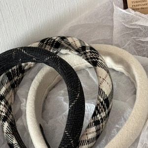 Detailed close-up of thick vintage plaid and solid sponge headbands with textured fabric