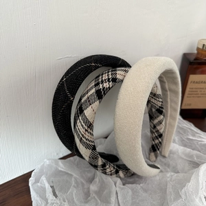 Detail of three retro plaid and solid sponge headbands with textured fabric close-up