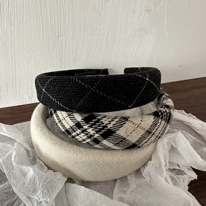 Close-up of three vintage thick sponge headbands in black and beige plaid fabric textures