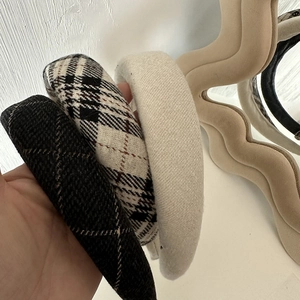 Close-up of thick plaid and cream sponge headbands with textured tweed fabric