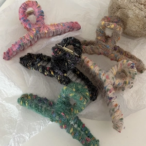 Dettaglio di fermagli per capelli in maglia multicolore con trama soffice e molla d'oro