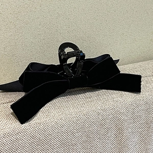 Détail d'une grande pince à cheveux avec nœud en velours noir de style vintage