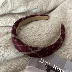 Close-up of vintage thick plaid headband in deep red and beige wool fabric