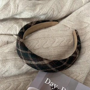 Detail of vintage british plaid padded headband in wool fabric with soft beige lining