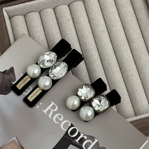 Set de quatre barrettes en velours noir avec perles et cristaux élégants sur un plateau