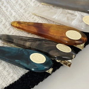 Elegant water-drop acetate hair clips with marble texture and golden metal accents
