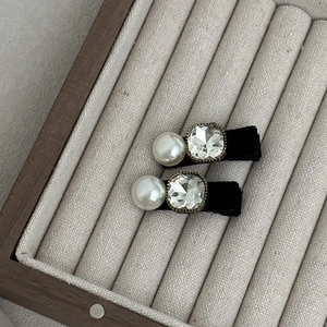Barrettes vintage avec perles, cristaux et velours noir sur un plateau à bijoux