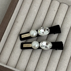 Détail de barrettes à cheveux en velours avec perles et cristaux sur un plateau doux
