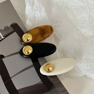 Three-piece acrylic hair clip set in tortoise, black, and cream with gold metal studs