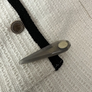 Detail of teardrop acetate hair clip in smoky grey with gold POKO FOSCA metal logo