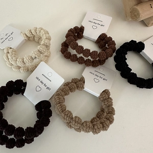 Set of wavy plush hair scrunchies in earth tones like beige and brown on white card