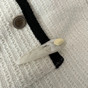 Close-up of teardrop acetate hair clip with marble pattern and gold metal plate